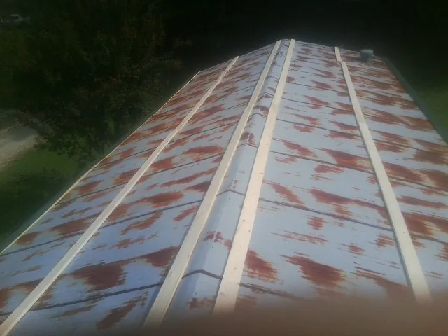 Rusted metal roof panels with new wood purlins before replacement — Storm Damage Roof Repair in Banks by Roofing Brothers