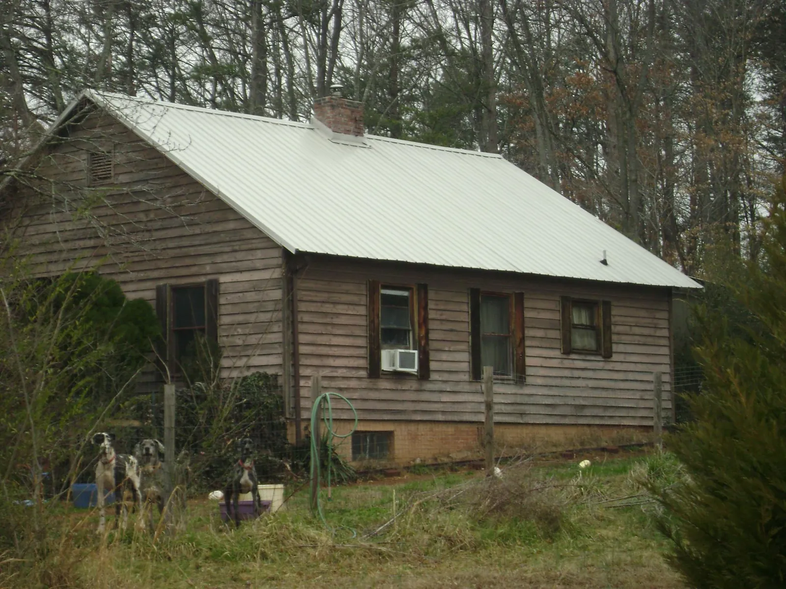 White metal roof on an old wood sided farmhouse, from a Metal Roof Installation job in Banks